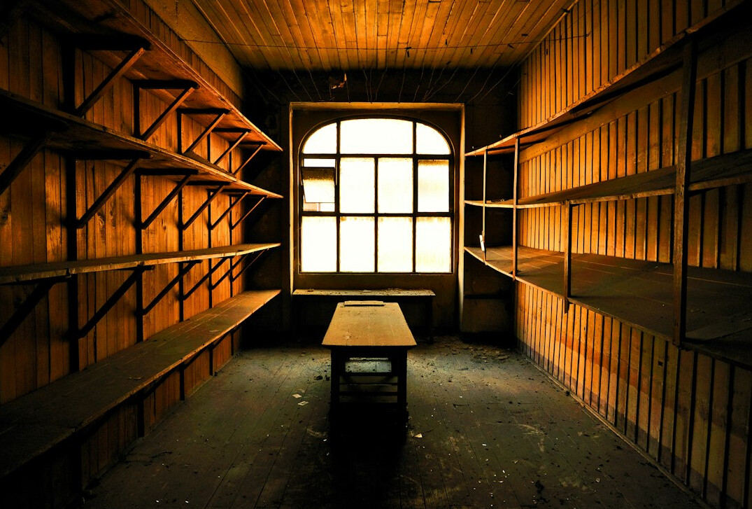 Historic archive reading room with tall shelves of bound case files and a wooden desk in window light