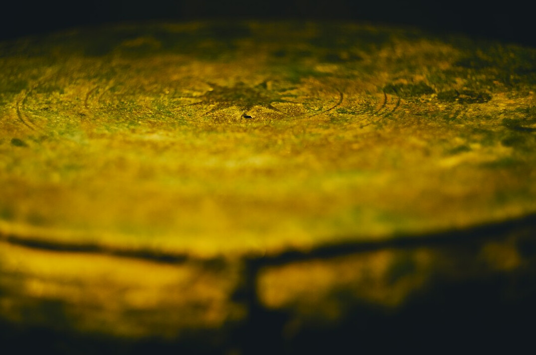 Old hand-drawn city plan spread on a table with a brass compass